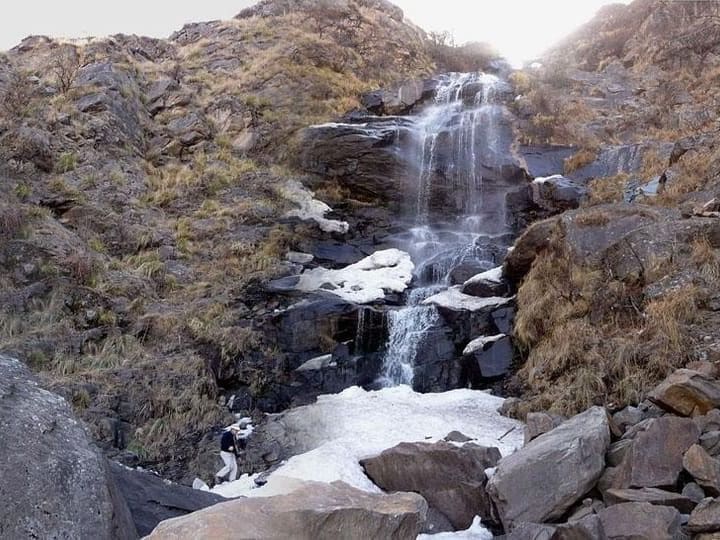 La cascada Los Alisos cayendo entre las rocas, con hielo en los bordes