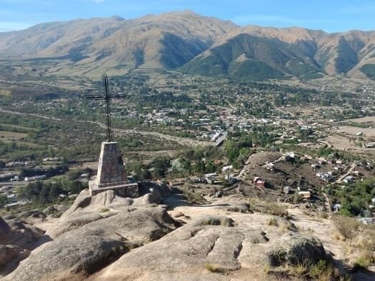 La cruz de la cumbre del cerro El Pelao, con el pueblo de Tafí y los cerros detrás
