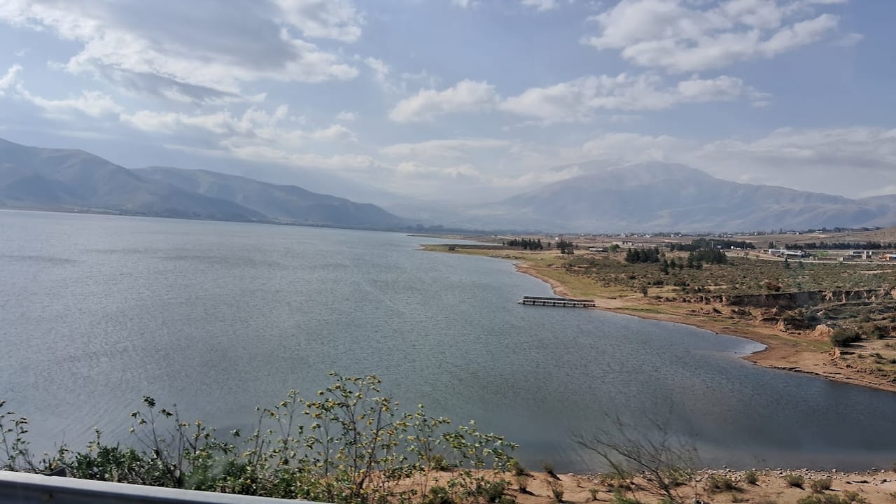 El embalse visto desde la ruta, con el muelle sobre el agua y el pueblo al fondo